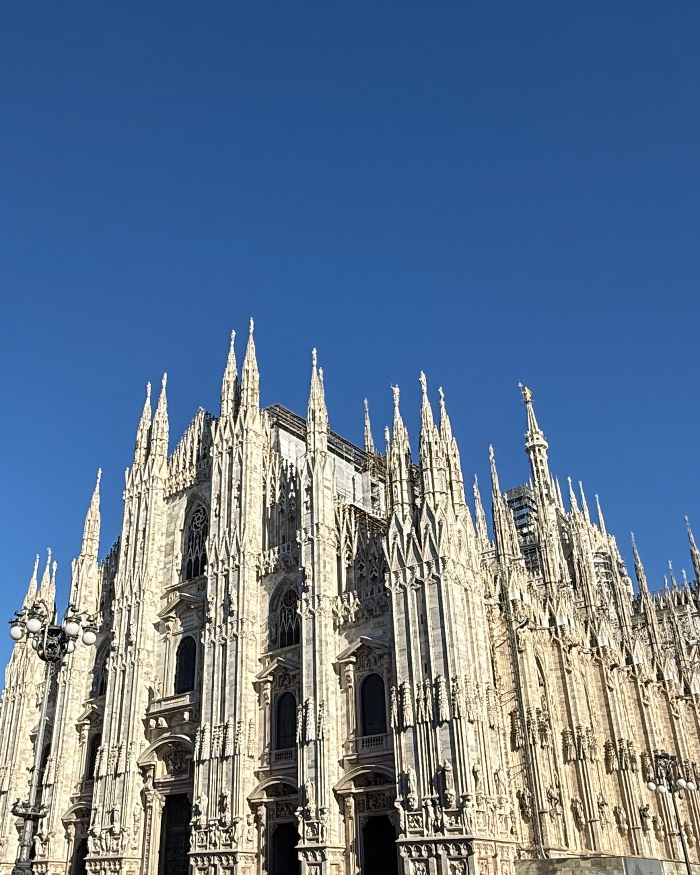 The spires of Milan Cathedral against a clear blue sky